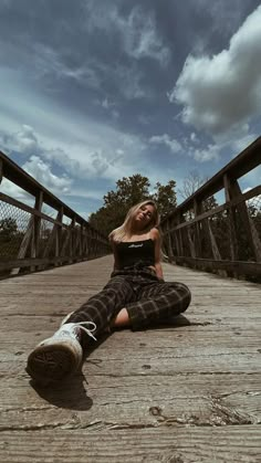 a woman is sitting on the ground with her legs crossed and looking at the camera