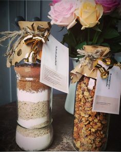 two jars filled with different types of granola next to each other on a table