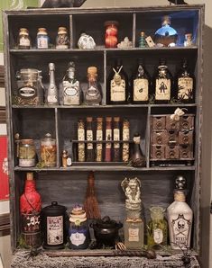 an old wooden shelf filled with lots of bottles and other items on top of it