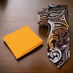 This silk necktie, featuring shades of brown, yellow gold, and white in a bold large paisley pattern, is a statement piece that exudes confidence and style. The warm tones of brown and gold create a rich, luxurious look, while the large paisley pattern adds an artistic flair. This tie is perfect for those who appreciate classic patterns with a modern twist, offering a vibrant and sophisticated appearance. Dress Shirts: White dress shirt – A white shirt provides a clean, crisp contrast to the bol Elegant Multicolor Suit And Tie Accessories For Formal Occasions, Elegant Multicolor Formal Suit And Tie Accessories, Elegant Multicolor Standard Tie, Elegant Multicolor Formal Neckwear, Elegant Paisley Print Suit And Tie Accessories For Gift, Elegant Paisley Print Tie As A Gift, Elegant Paisley Print Ties As Gift, Elegant Multicolor Neckwear With Ties, Elegant Multicolor Neckwear For Business