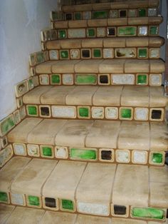 a set of stairs with green and white tiles on the bottom, in front of a wall