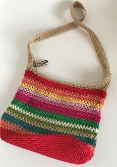 a crocheted purse is shown on a white surface with a hook in the middle