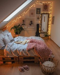 an attic bedroom decorated in white with string lights and pink slippers on the floor