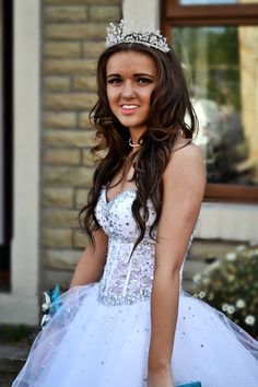 a young woman in a white dress and tiara