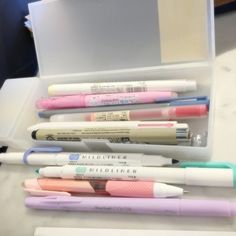 several pens are lined up in a plastic container