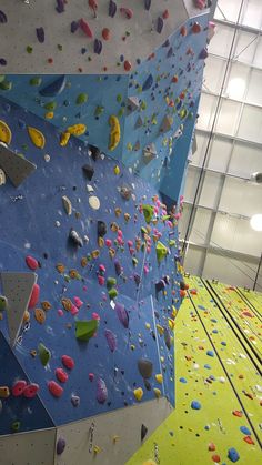 an indoor climbing wall with various colored rocks