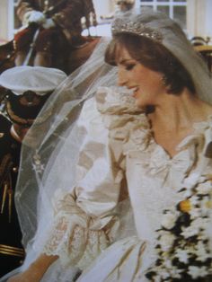 a woman in a wedding dress sitting next to a horse