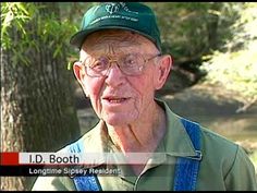 an older man wearing glasses and a green hat is talking to someone on the news