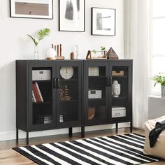 a living room scene with focus on the black cabinet and white rugs in the foreground