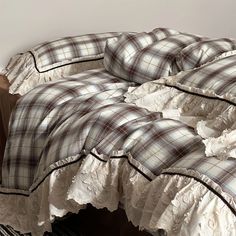 an unmade bed with plaid sheets and ruffled edges