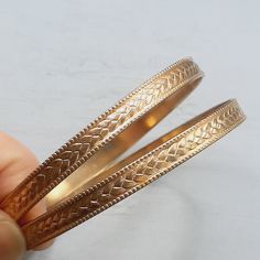 A PAIR of matching goldtone metal bangles, c.1970s in date. The bangles are slim, approx. 6mm wide in sturdy goldtone metal. The metal has a slight patina to it and is quite a rich gold colour. Approx. 68mm across inside. In excellent vintage condition, please see all photos. For more gorgeous vintage jewelry, please see my shop: http://www.etsy.com/shop/RagtimeBazaar?ref=si_shop Please be aware that I'm based in the UK, so international orders will take longer to arrive. Vintage Gold Brass Bangle, Vintage Gold Adjustable Bangle, Adjustable Vintage Gold Bangle, Antique Gold Metal Bangle, Vintage Yellow Gold Brass Bangle, Vintage Yellow Gold Metal Bangle, Gold Hoop Bangle In Metal, Gold Metal Bangle For Anniversary, Vintage Metal Bangle For Anniversary