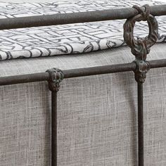 an iron bed frame with a white and black pillow