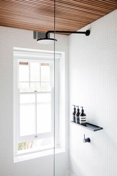 a bathroom with white tile and wooden ceiling