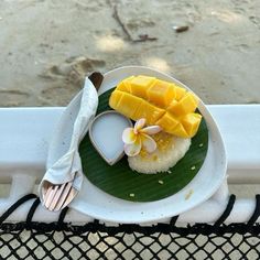 a white plate topped with food on top of a metal table next to a fence