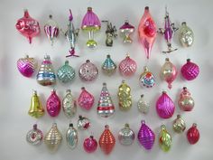 an assortment of christmas ornaments are displayed on a white surface