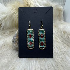 Hand-beaded by Chippewa Beadwork, these gold-plated geometric earrings feature vibrant red and turquoise beads. Elevate any outfit with these stunning statement earrings, perfect for adding a touch of color and culture to your look. Expertly crafted and unique, these earrings are a must-have for any jewelry collection. 11/0 Miyuki beads Gold-plated geometric earring connectors Hypoallergenic earring hooks Handmade by Chippewa Beadwork Chippewa Beadwork, How To Mk, Earring Connectors, Red And Turquoise, Miyuki Beads, Hypoallergenic Earrings, I Love Jewelry, Earring Hooks, Geometric Earrings