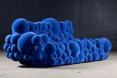 a blue couch sitting on top of a cement floor