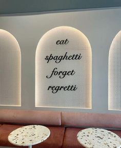 an empty restaurant with tables and chairs in front of the wall that says eat spaghettii for