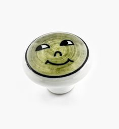 a green and white knob with a smiley face on it