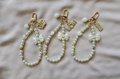 three different types of beaded earrings on a white sheet, one with gold charms and the other with pearls