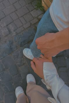 two people sitting on the ground holding hands