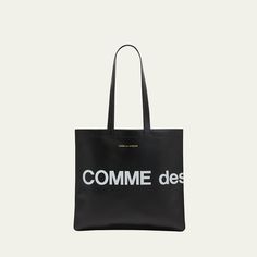 Comme des Garcons tote bag in smooth leather features a "Huge Logo" design Foiled logo lettering Two flat top handles Open top Interior, one zip pocket Approx. 25.984"H  x 15.748"W x 0.787"D Leather Imported Luxury Shoulder Bag With Logo Print For Travel, Luxury Logo Print Shoulder Bag For Travel, Designer Black Bag With Logo Print, Luxury Rectangular Bags With Logo Print, Luxury Rectangular Bag With Logo Print, Business Leather Shoulder Bag With Logo, Leather Shoulder Bag With Logo For Business, Leather Business Shoulder Bag With Logo, Everyday Top Handle Bags With Logo Print