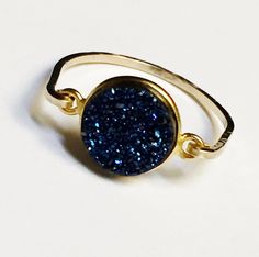 Druzy Ring has a beautifully cut cabochon blue druzy gemstone wrapped in 14k gold filled wire. This Blue Druzy gemstone ring is designed to shine! Blue Druzy gemstone bezel is 8-10mm diameter size in this gold filled ring. Due to the natural formation of these druzy gemstones no two are alike and each gemstone may vary in size, shape and texture to give that natural organic look and will not look exactly like the gemstone pictured. You are not purchasing the exact stone in the picture. Ring size Adjustable Blue 14k Gold Rings, Nickel-free Blue Crystal Ring, Adjustable Blue Crystal Ring, Adjustable Nickel-free Blue Stackable Rings, Adjustable Blue Rings With Bezel Setting, Adjustable Blue Ring With Bezel Setting, Adjustable Blue Sapphire Ring, Adjustable Blue Stackable Crystal Ring, Adjustable Blue Stackable Rings, Fine Jewelry