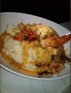 a white bowl filled with food on top of a table