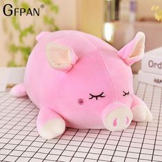 a pink pig stuffed animal sitting on top of a table