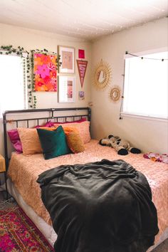 a bed room with a neatly made bed and pictures on the wall