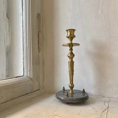 a candle holder sitting on top of a table next to a window