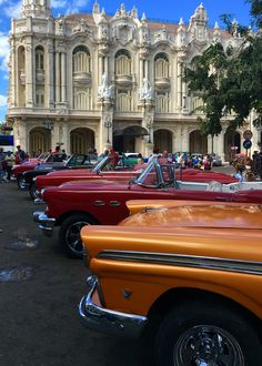 several classic cars parked in front of an old building