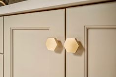 two hexagonal knobs on the front of a kitchen cabinet