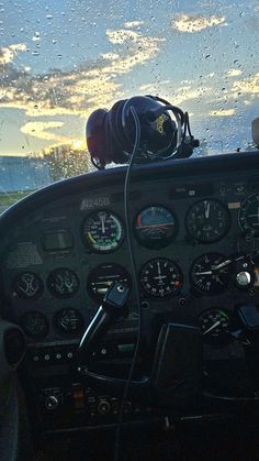 the inside of an airplane cockpit with water droplets on the window and dashboards in view