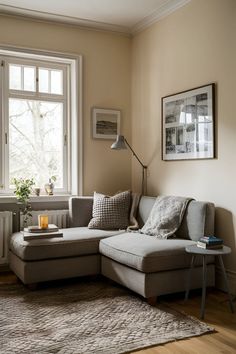 a living room filled with furniture and a lamp on top of a wooden floor next to a window