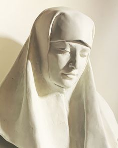 a statue of a woman with a white veil on it's head and her eyes closed