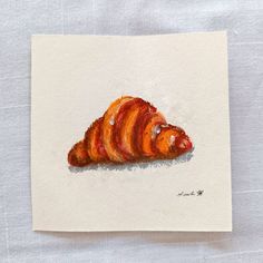 a painting of a croissant sitting on top of a piece of white paper