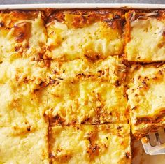 a casserole dish with cheese on top and a fork stuck in the bottom