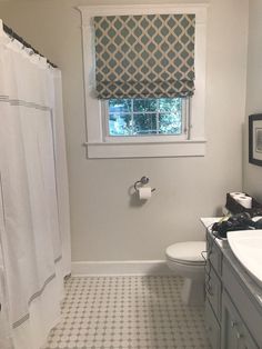 a bathroom with a sink, toilet and window