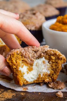 a person picking up a muffin from a plate