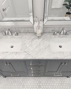 two sinks and mirrors in a bathroom with hexagonal tiles on the flooring