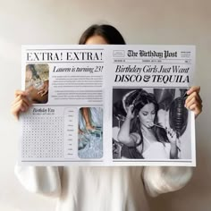 a woman holding up a newspaper with pictures on it