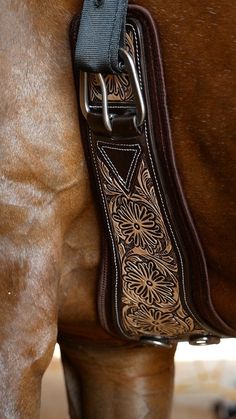 the back end of a horse's bridle with a floral design on it