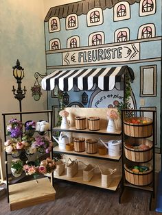 a display case with baskets and flowers in front of a wall mural that reads florists