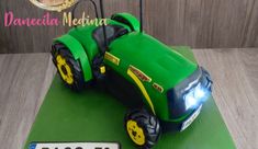 a green cake with a tractor on it and a name plate in front of it