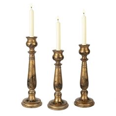 three brass candlesticks with one lit and the other turned off