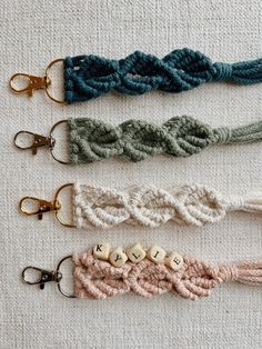 four crocheted key fobs are lined up on a white tablecloth