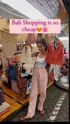 a woman standing in front of a store holding up a pink sign that says bail shopping is so cheap