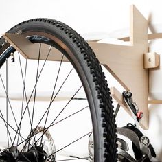 a close up of a bike tire on a wall mounted bicycle rack in a room with white walls