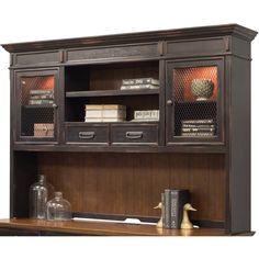 a book shelf with drawers and books on top of it, next to a desk